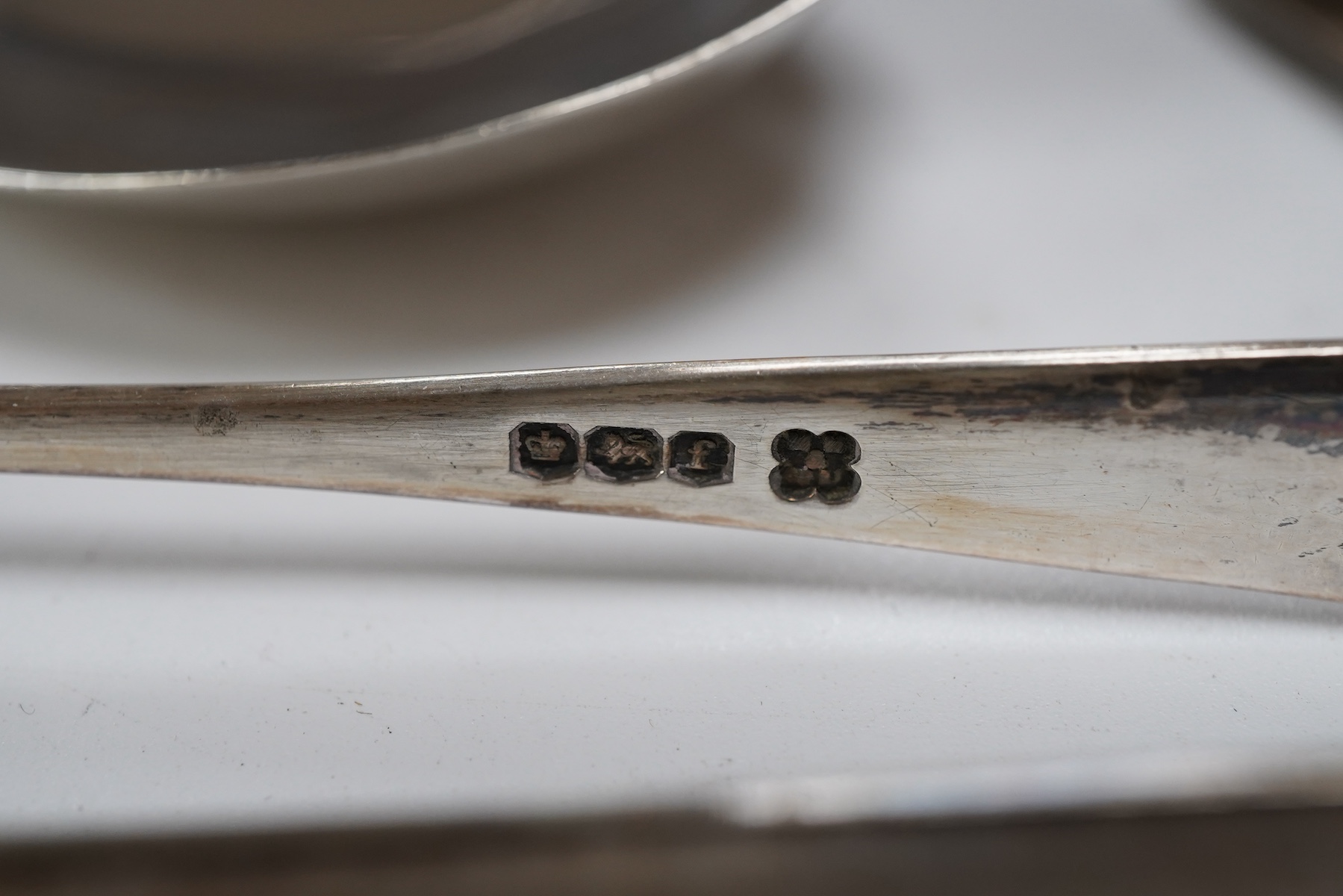 A Victorian silver bun salt, London, 1860, a later silver cigarette case, a silver napkin ring and pair of silver sugar tongs, together with a continental white metal serving spoon and a silver plated oval tray.